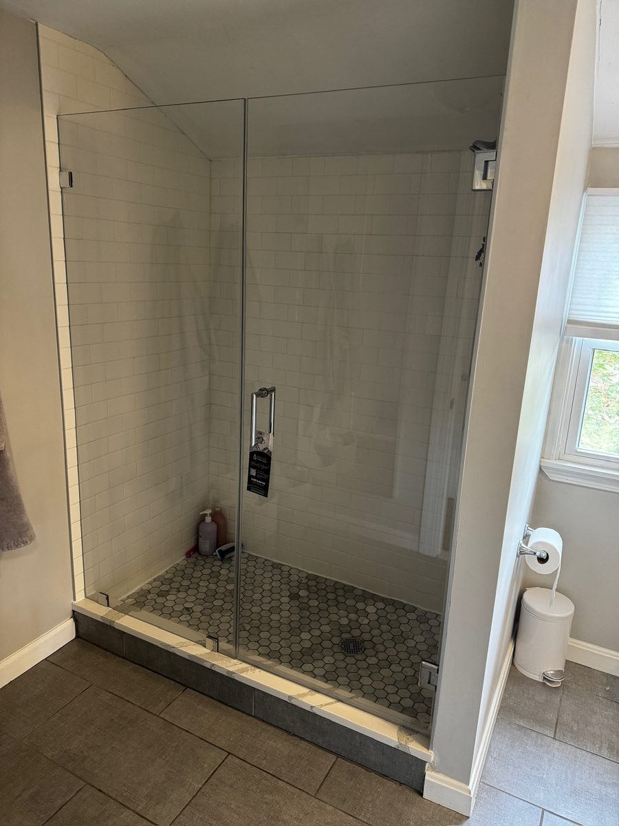 Frameless pivot shower door Natick MA white subway tile